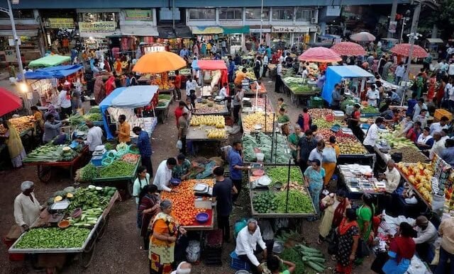 customers buy fruits and vegetables at an open air evening market in ahmedabad india photo reuters