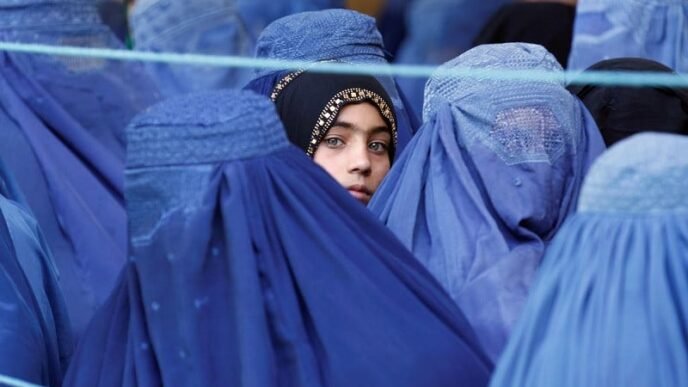 a girl looks on among afghan women lining up to receive relief assistance in jalalabad afghanistan june 11 2017 photo reuters