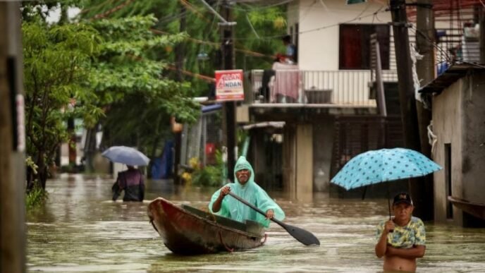 people wade through the floodwaters as it rains during tropical storm yagi locally known as enteng in apalit pampanga philippines september 5 2024 photo reuters