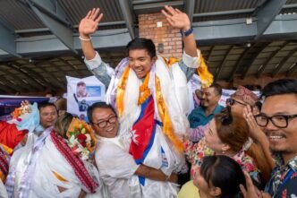 A record-setting teen climber returns home to Nepal to a hero's welcome