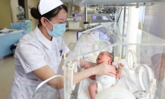 A medical staff member cares for a newborn at the neonatal care unit of a hospital in Lianyungang, East China