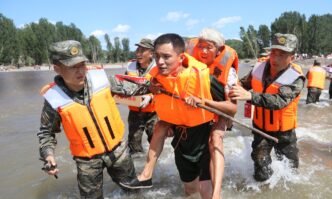 Armed Police Force carry a local resident to safety during a flood in Huludao city in Liaoning Province on August 23, 2024. Photo: VCG