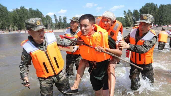 Armed Police Force carry a local resident to safety during a flood in Huludao city in Liaoning Province on August 23, 2024. Photo: VCG
