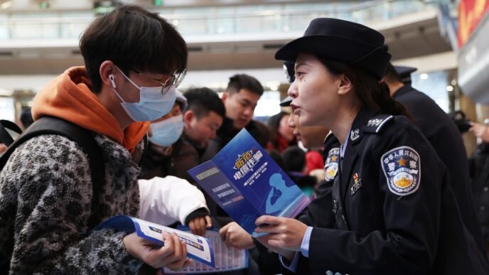A police officer disseminates anti-telecom fraud information to passengers at the Beijing West Railway Station, on January 14, 2025. Photo: IC