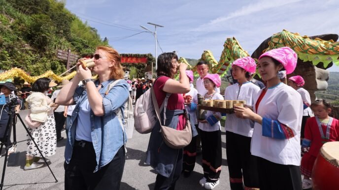 Foreign visitors taste local drinks during the Terraced Fields Plowing Festival held in Guilin, South China