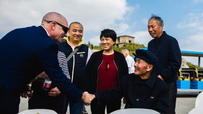A relative of a British POW shakes hands with Chinese fisherman Lin Agen (in the hat) who helped rescue POWs during the sinking of the Lisbon Maru in 1942, in October 2019. Photo: Courtesy of Fang Li